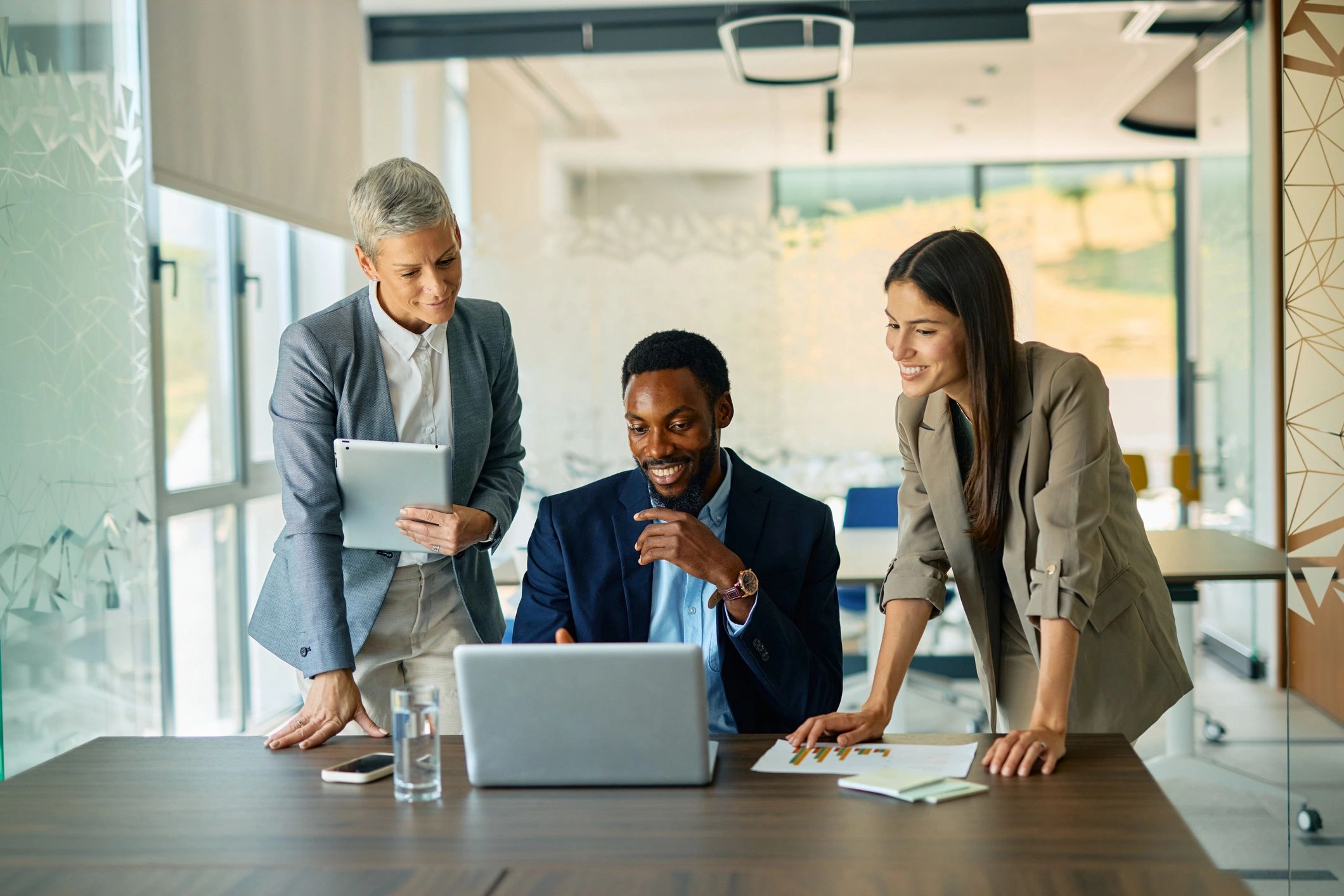 Professionals collaborating with a laptop in a modern office